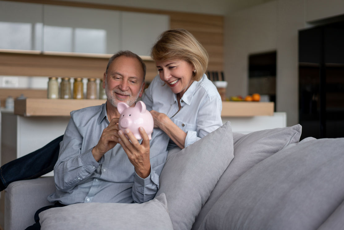 Paar mit Sparschwein hat von Steuerspartipps für Ihre Pensionierung profitiert.